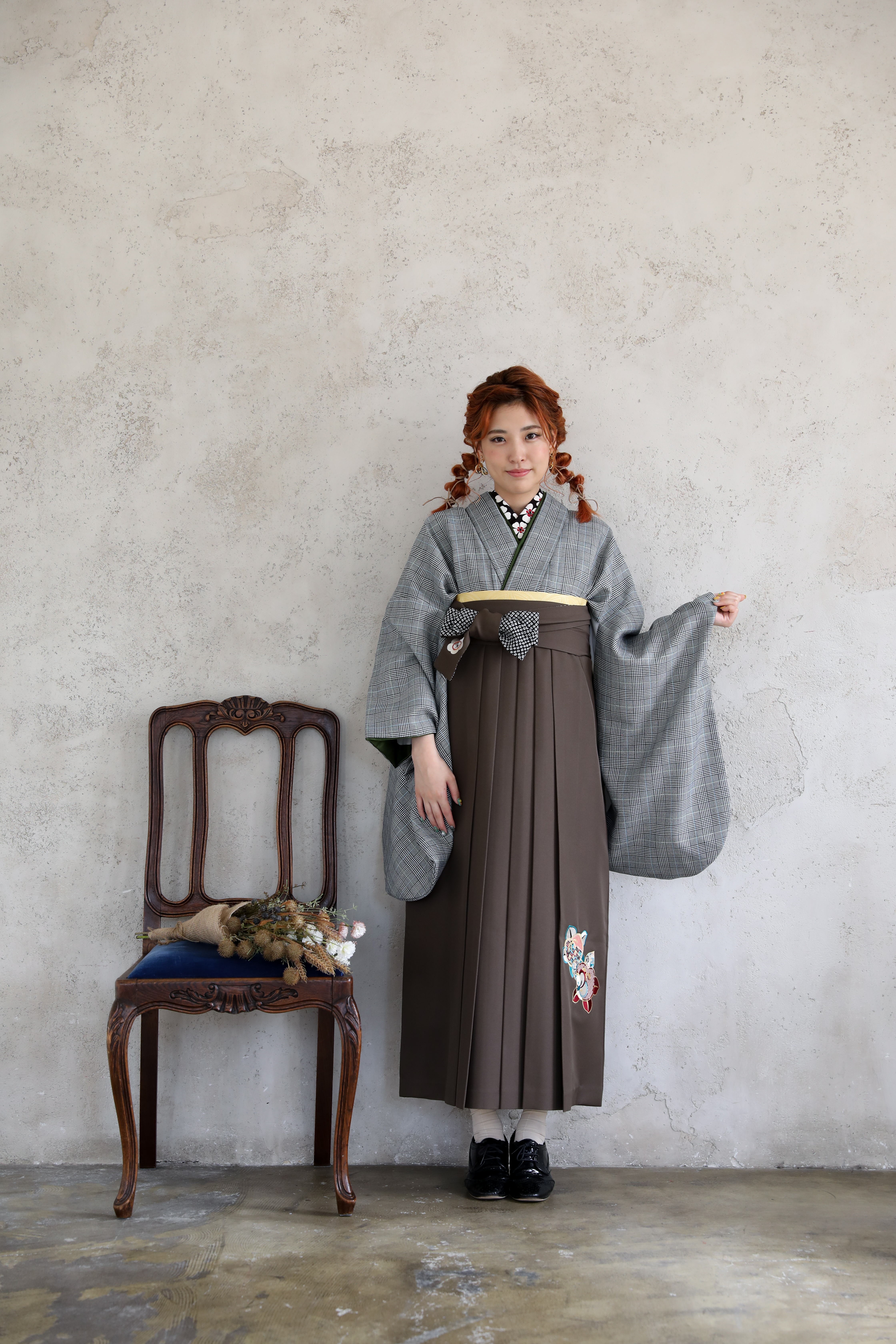 ラフィネモカ（Raffine Mocha）ブランドの、グレンチェックの二尺袖と、グレーの袴の女性用卒業式袴を着用した全身写真