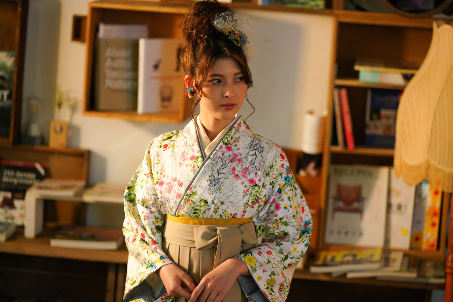 ラフィネモカ（Raffine Mocha）ブランドの、白地にカラフルな総小花柄の二尺袖と、ベージュ色の袴の女性用卒業式袴を着用したアップ写真