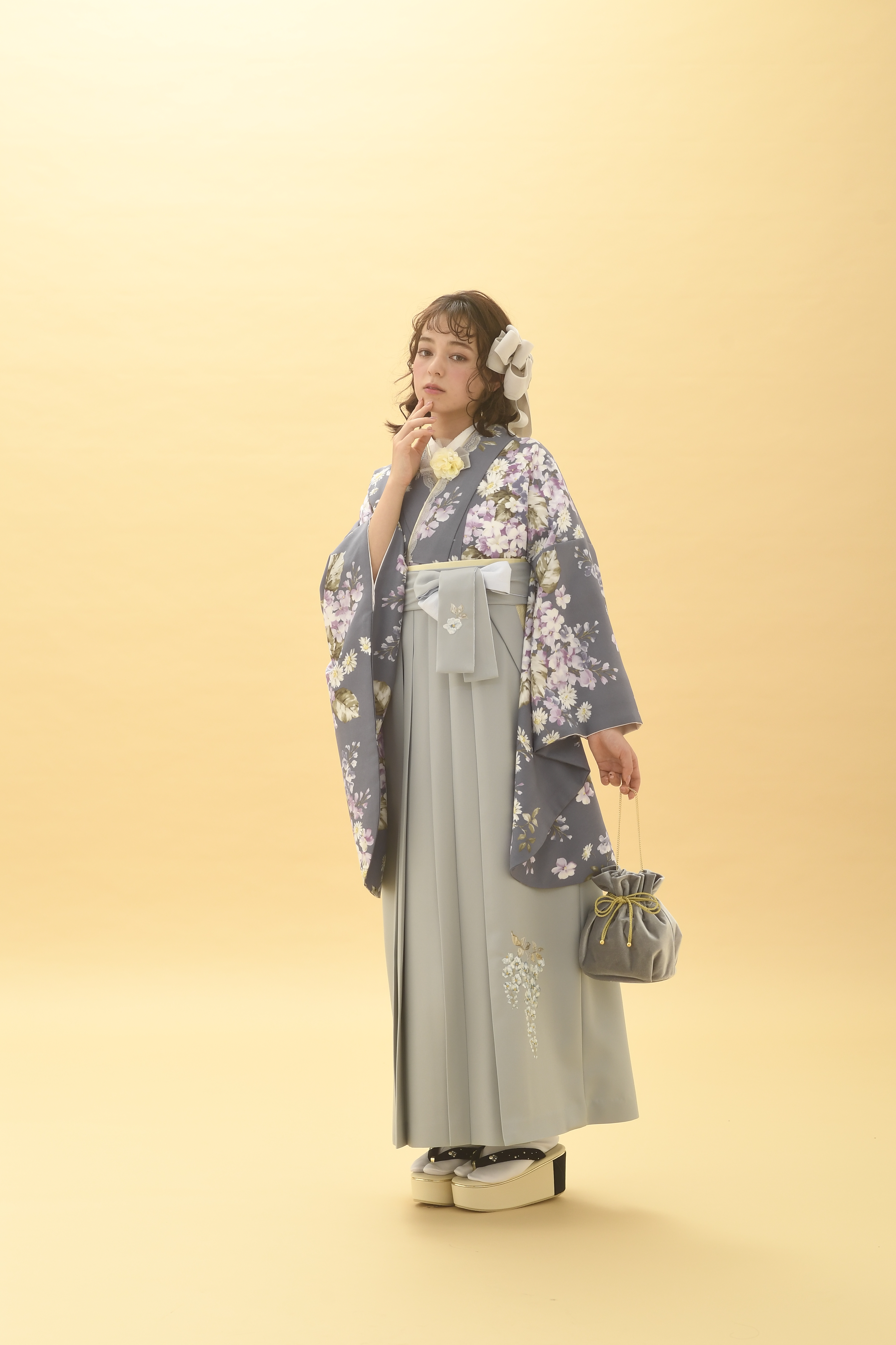 シュガーKブランドの、グレー地に白の小花柄の二尺袖と、グレーの袴の女性用卒業式袴を着用した全身写真