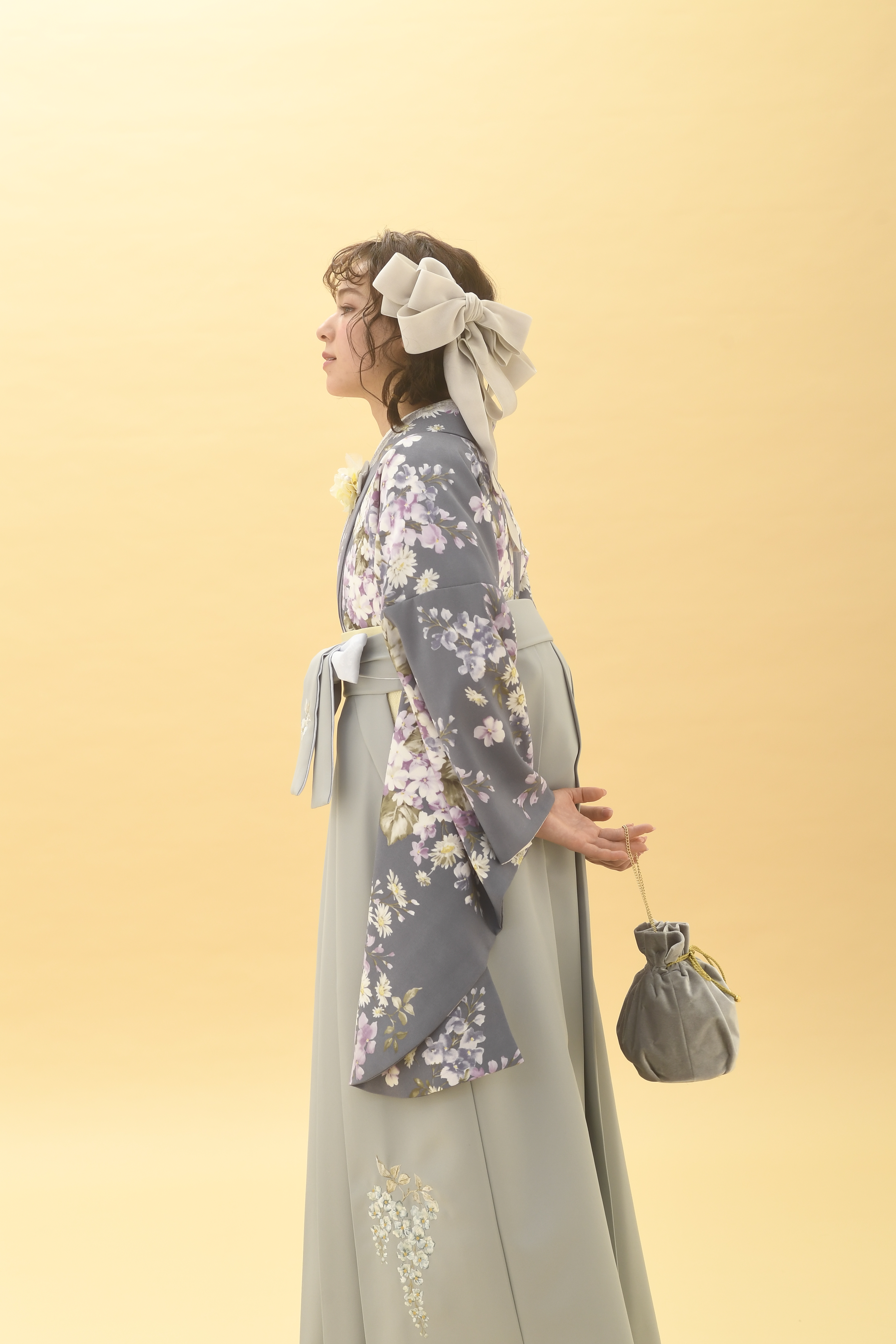 シュガーKブランドの、グレー地に白の小花柄の二尺袖と、グレーの袴の女性用卒業式袴を着用したアップ写真