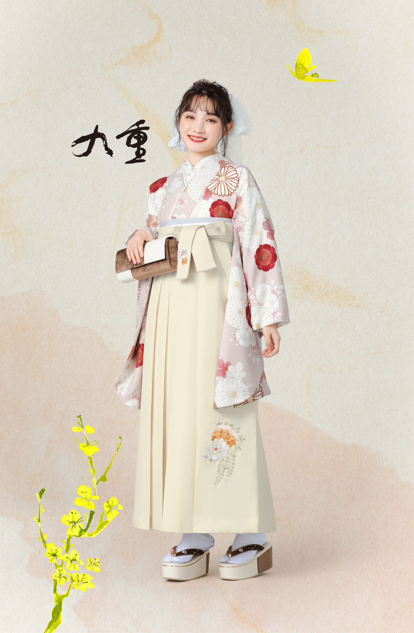 九重ブランドの、ピンク地に白の花柄の二尺袖とクリーム色の袴の女性用卒業式袴を着用した全身写真