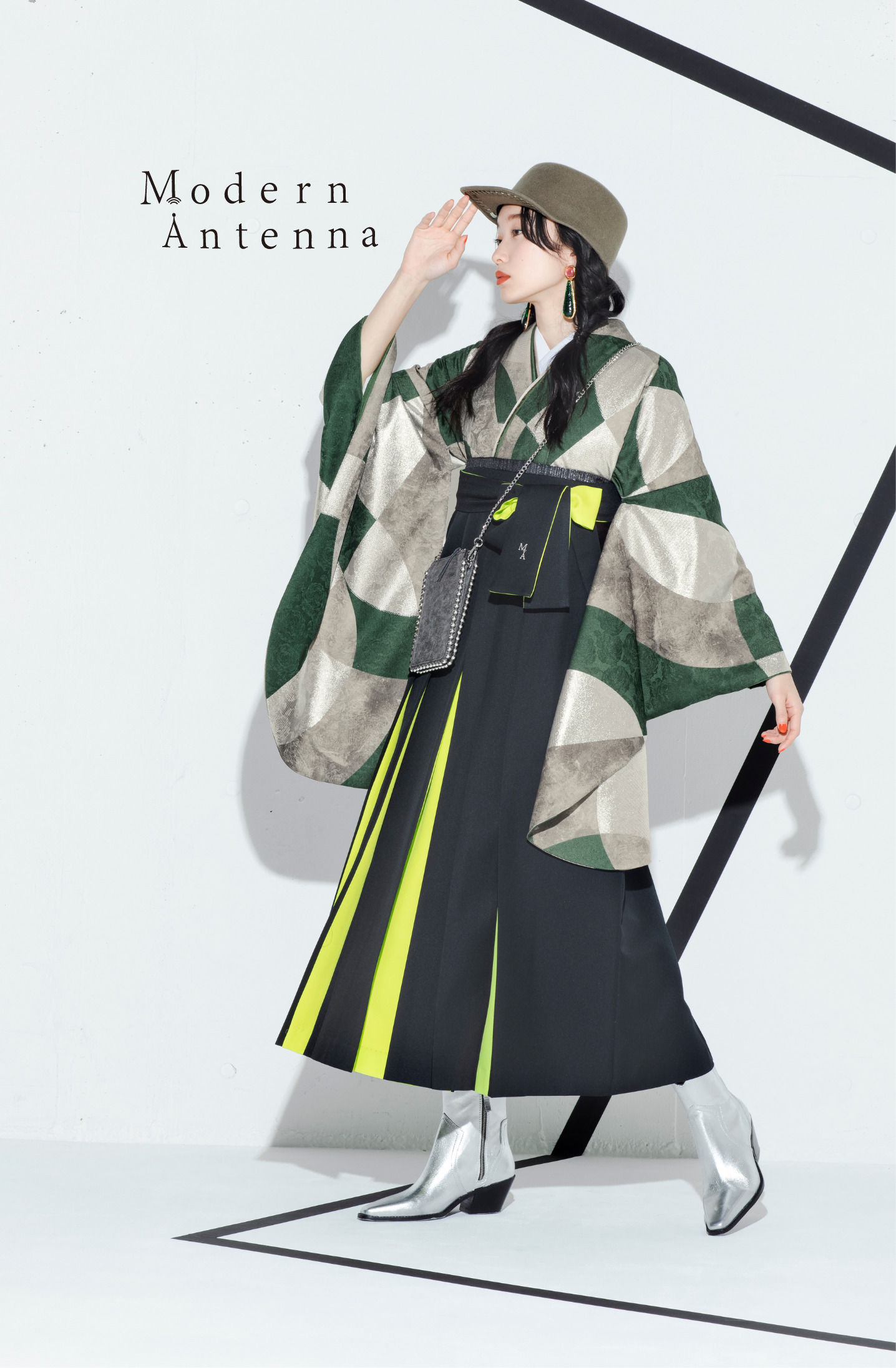 モダンアンテナ（Modern Antenna）ブランドの、緑の幾何学模様の二尺袖と、黒と黄色の袴の女性用卒業式袴を着用した全身写真