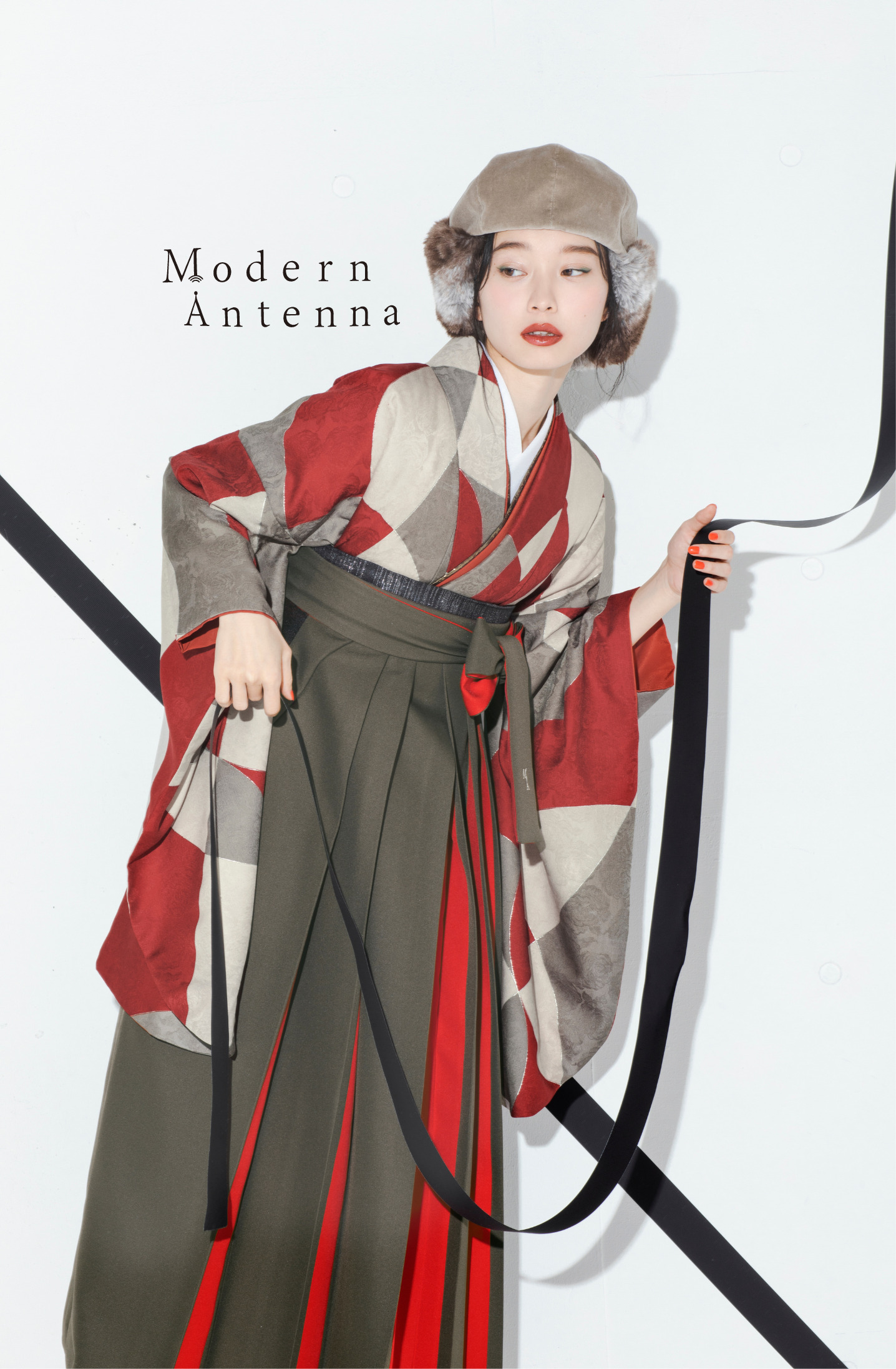 モダンアンテナ（Modern Antenna）ブランドの、赤の幾何学模様の二尺袖と、グレーと赤の袴の女性用卒業式袴を着用したアップ写真