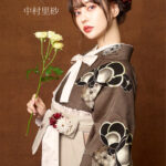 JAPAN STYLE×中村里砂ブランドの、ブラウンの花柄の二尺袖と、クリームの袴の女性用卒業式袴を着用したアップ写真